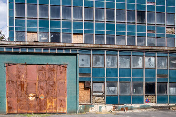 Rusty gate to a blue house facade