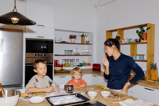 Family baking christmas cookies together in kitchen