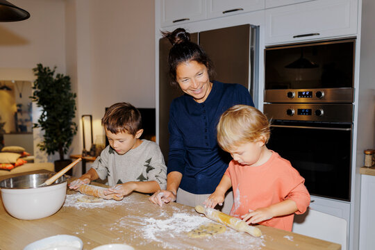 Mother and children baking christmas cookies in kitchen