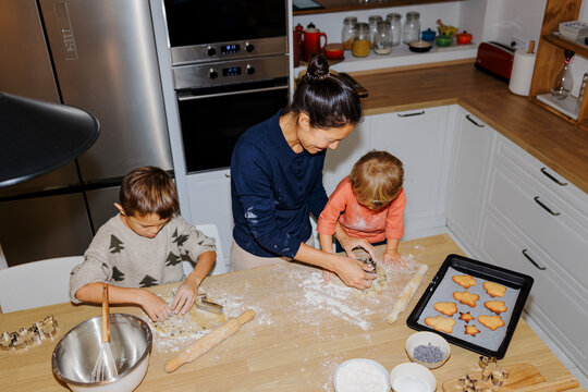Family baking christmas cookies together in kitchen