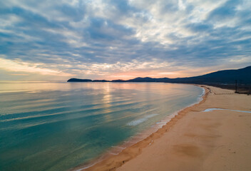 Beautiful coastal sunset with soft waves and serene landscape captured in the evening sky