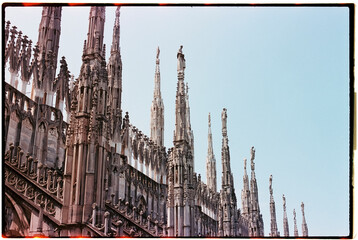 gothic spires of the Milan Cathedral under a pale blue sky, 35mm film