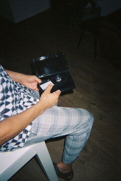 a man holding a home video cassette, 35mm film