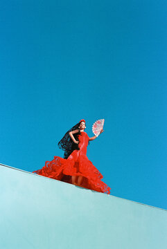 flamenco doll in red on a turquoise wall, 35mm film