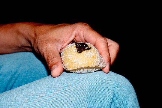 a man holding a Polenta e Osei pastry from Bergamo
