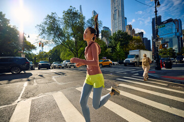 Sportswoman jogs across the street