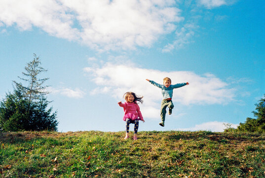 Happy kids jump and play in public park
