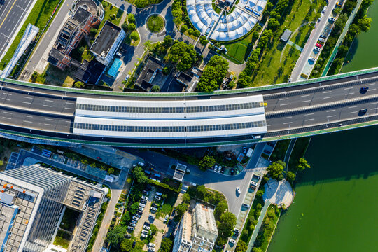 Aerial view of city overpass with solar panels and green surroundings