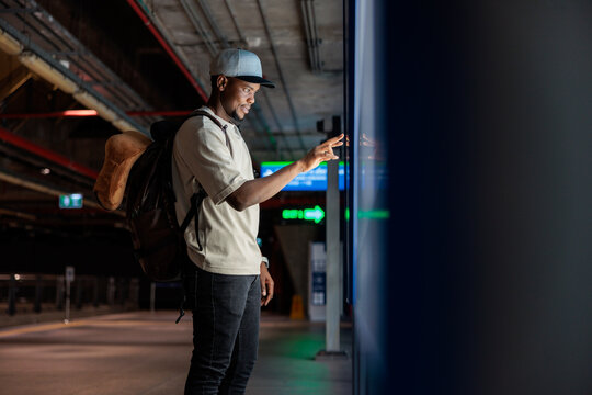 Traveler uses touch screen at train station.