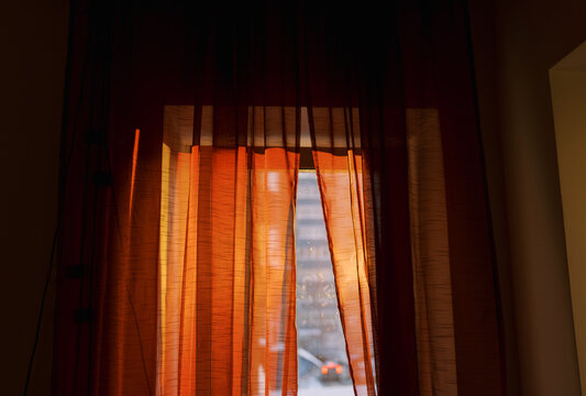 Golden Sunlight Filters Through Sheer Orange Curtains in a Cozy Room