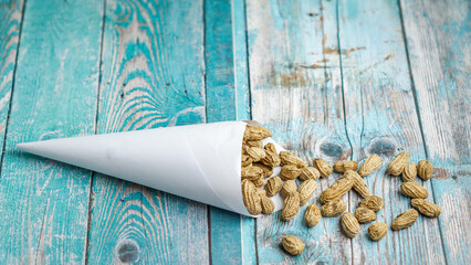 Boiled peanuts wrapped in cone-shaped paper on a rustic table