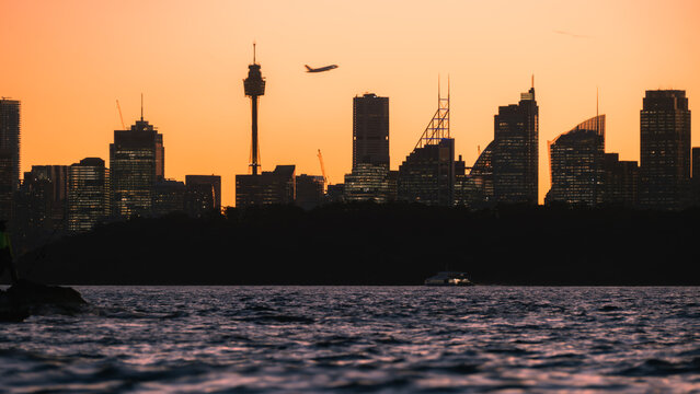 Airplane over Sydney Skyline at Sunset