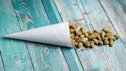 Boiled peanuts wrapped in cone-shaped paper on a rustic table
