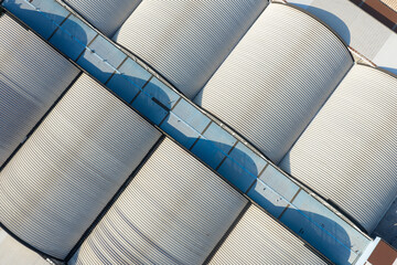 Aerial view of curved metal roofs of industrial warehouse buildings