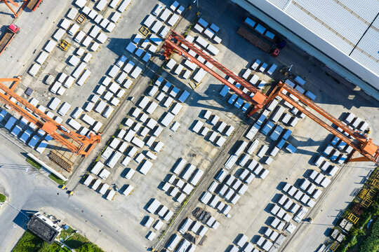Aerial view of industrial yard with cranes and concrete blocks