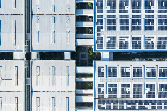 Aerial view of modern factory roofs with solar panel arrays