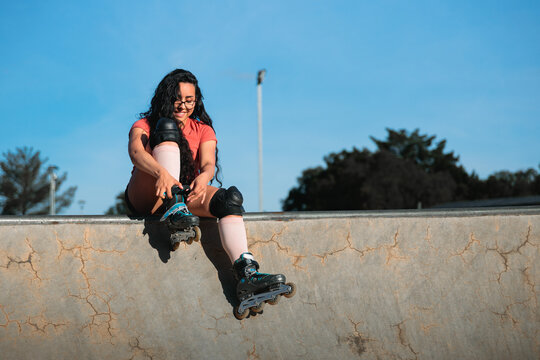 Rollerblader Adjusting Her Skates at the Skatepark
