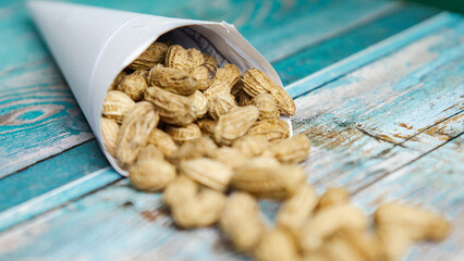 Boiled peanuts wrapped in cone-shaped paper on a rustic table