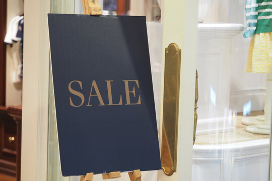 Sale sign in a boutique enticing shoppers in a busy store