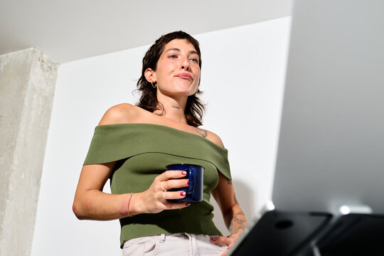 During a video call in the office holding a cup of coffee