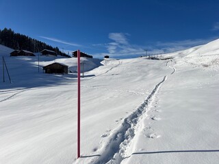 Wonderful winter hiking trails and traces in the fresh alpine snow cover of the Swiss Alps and over the village of St. Ant&ouml;nien - Canton of Grisons, Switzerland (Kanton Graub&uuml;nden, Schweiz)
