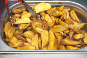 Golden potato wedges served on a silver tray
