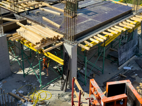 Wood, Yellow Beams, and Scaffolding Supports Around Concrete Columns