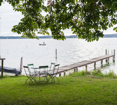 Lakeside Chairs Under a Tree Near a Wooden Dock