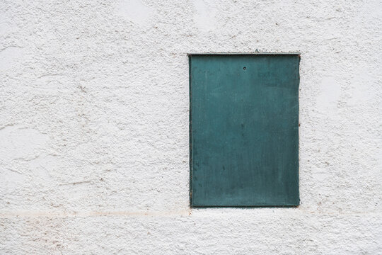 Teal Metal Panel on White Textured Stucco Wall