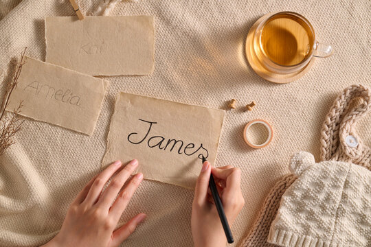 A person writing the name James on paper