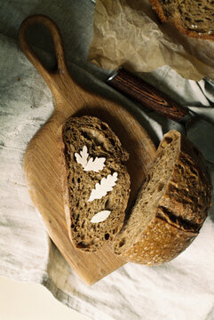 Rustic bread with butter leaves on wooden board