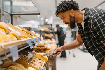 Selecting Fresh Bread and Pastries in Store Bakery Section