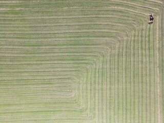 Aerial view of a tractor preparing hay in the field for making straw bales - Vue a&eacute;rienne d'un tracteur pr&eacute;parant le foin dans le champ pour la confection des bottes de paille
