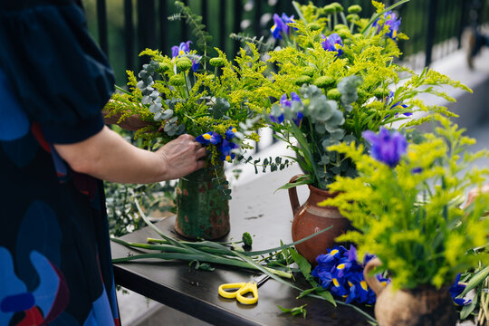 Anonymous person arranging flowers in vases