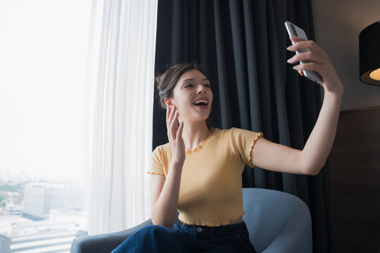 Young Hispanic American Gen Z Woman Using Smartphone for Video Call and Selfie in Digital Lifestyle. - Powered by Adobe
