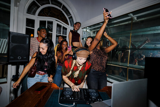 Young people enjoying live music party with female dj
