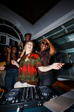 Woman disc jockey mixing music at party