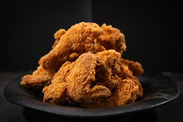 Crispy Golden Fried Chicken Pieces on a Dark Plate