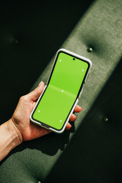 Mock-up foldable hone with empty screen on green leather background