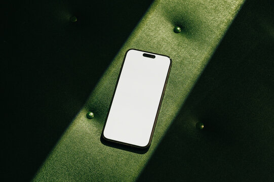 Mock-up phone with empty screen on green leather background