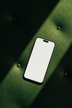 Mock-up phone with empty screen on green leather background