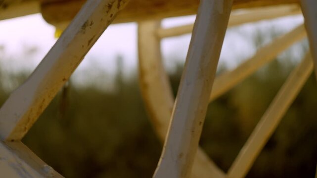Close-up of a traditional wooden wheel bathed in golden light on the Roc&iacute;o trail