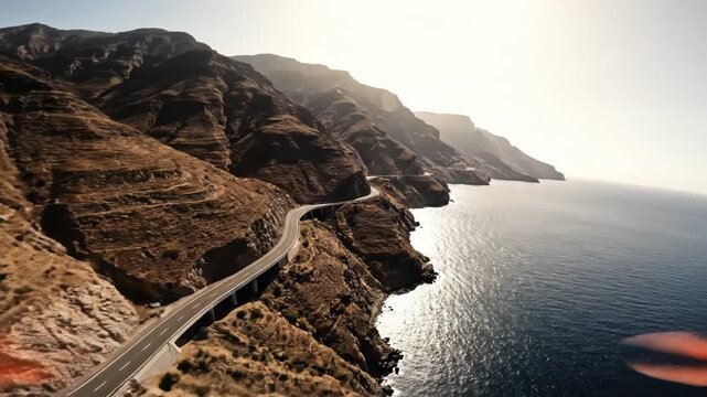 Aerial view of winding coastal road carved into steep, arid mountain cliff overlooking deep blue ocean water vector illustration