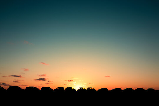 Parked Cars Silhouetted Against Sunset Sky