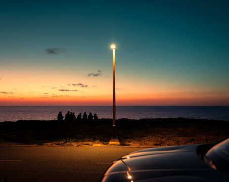 Friends enjoying striking sunset during road trip