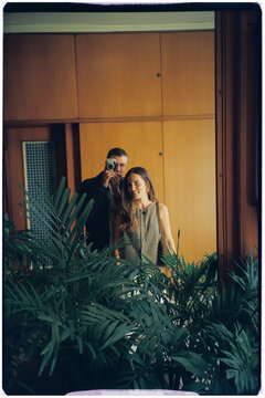 Analog image of a full-length reflection of two tourists in a mirror