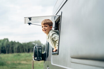 Happy boy enjoying freedom during van life road trip