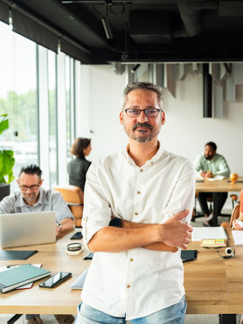 Confident Professional Man with Glasses Leads Modern Office Team