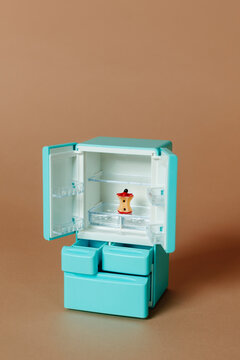 single apple core in an empty tiny turquoise refrigerator
