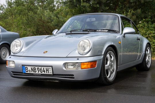 LINTHE, GERMANY - JUNE 08, 2025: The sports 2-door Porsche 911 (964) classic coupe in silver color under rain. Die oldtimer show.